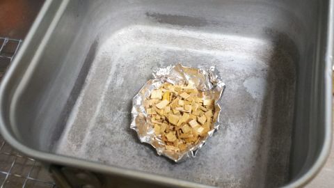 アルミホイルで作った小皿に燻製チップを盛って鍋の底に置きます。